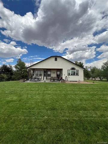 a aerial view of a house next to a yard with big trees