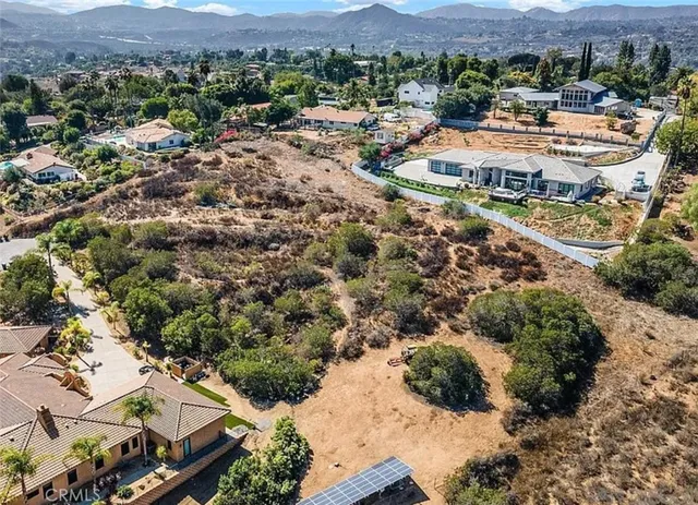 an aerial view of residential house with yard and mountain view in back