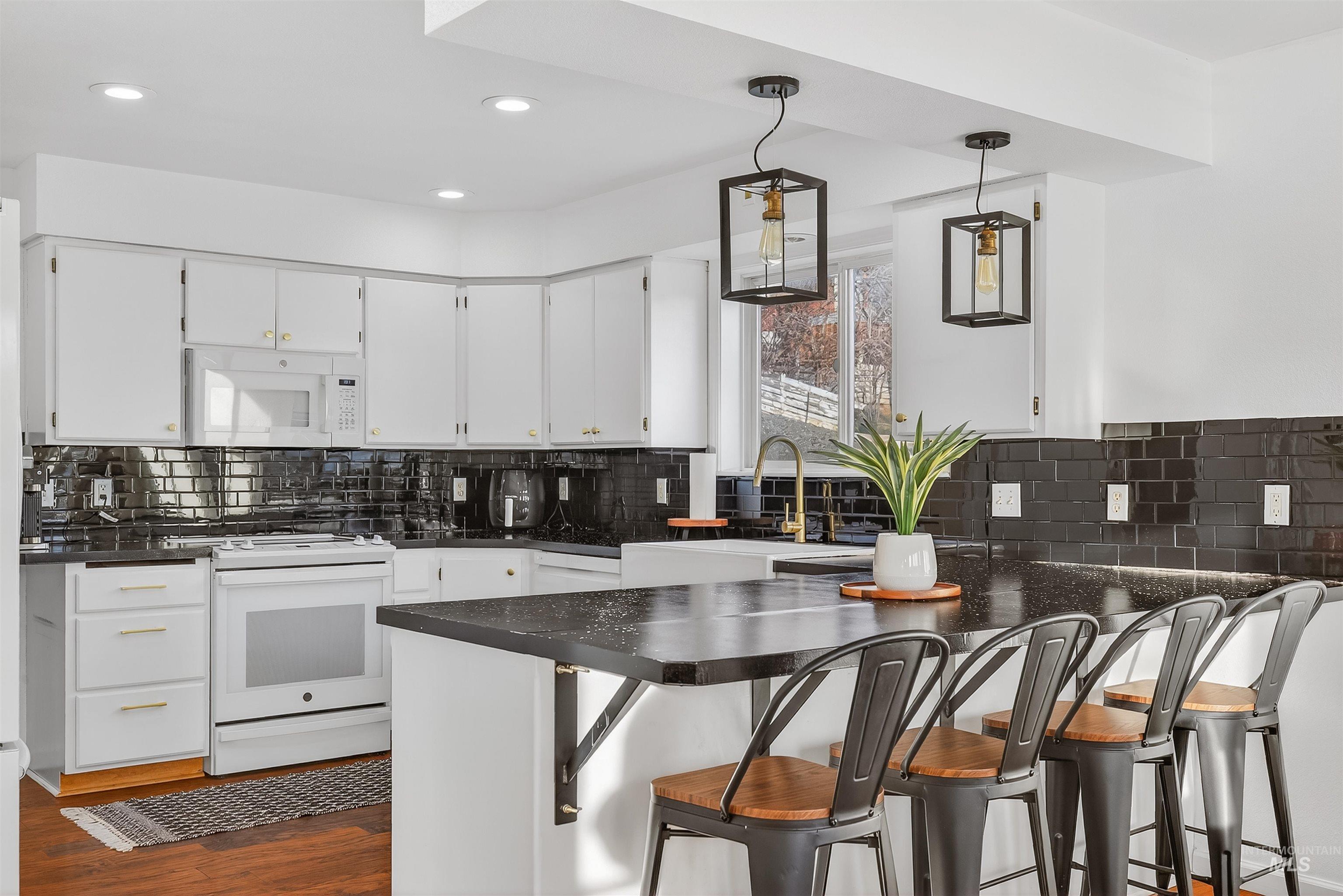 822 15th Avenue Lewiston, ID 83501 - Photo 11 of 44 Kitchen featuring pendant lighting, a kitchen breakfast bar, white appliances, white cabinetry, and recessed lighting