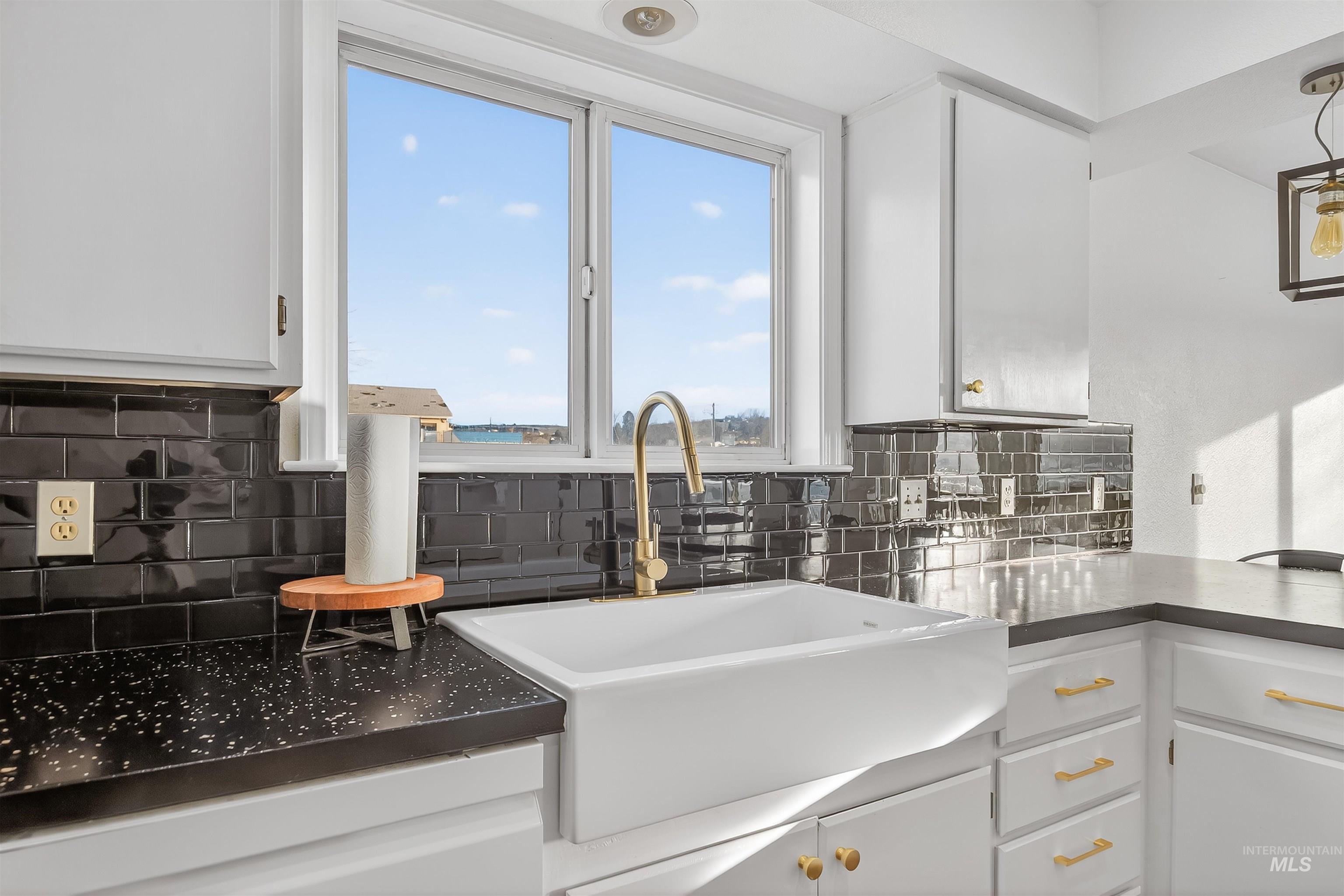 822 15th Avenue Lewiston, ID 83501 - Photo 18 of 44 Kitchen with white cabinets, dark countertops, and backsplash