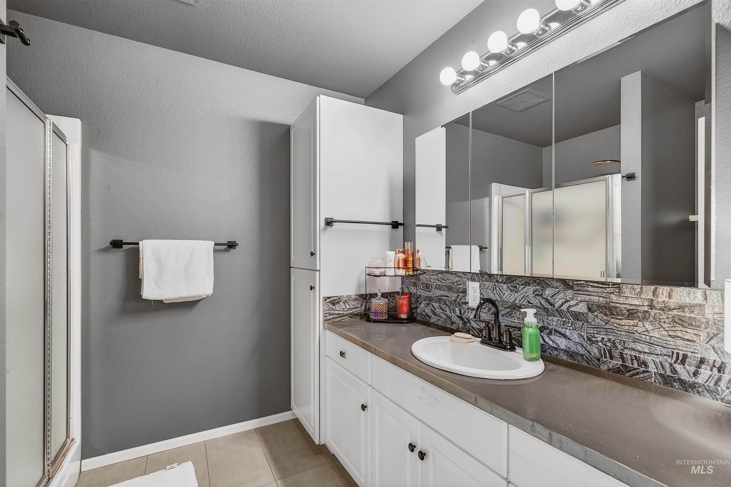 822 15th Avenue Lewiston, ID 83501 - Photo 26 of 44 Full bath with vanity, a stall shower, light tile patterned floors, and tasteful backsplash