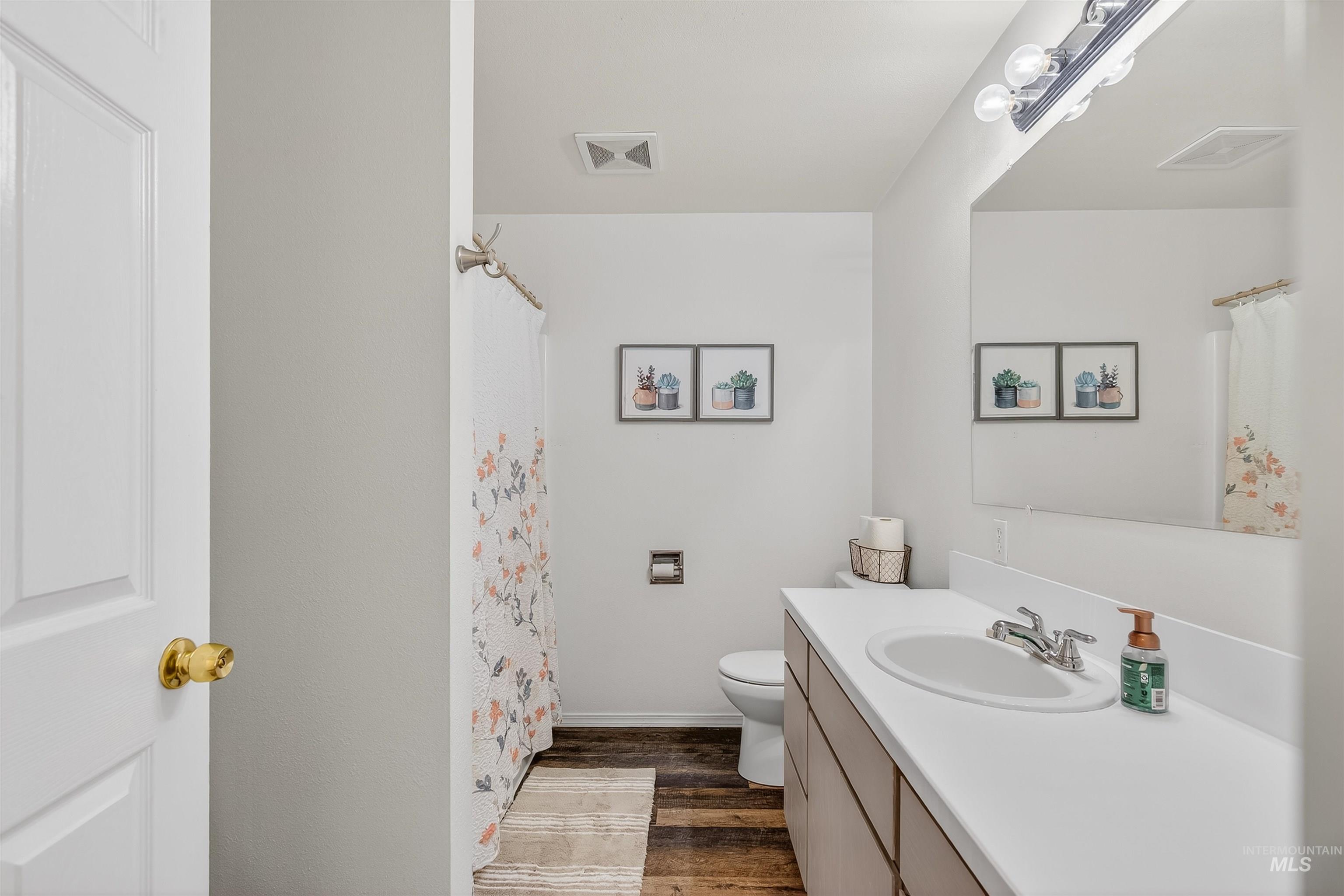 822 15th Avenue Lewiston, ID 83501 - Photo 34 of 44 Bathroom featuring vanity, curtained shower, and dark wood-style flooring