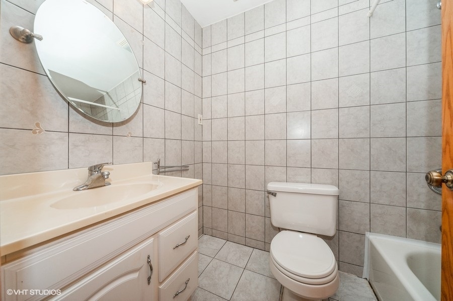 10357 Dearlove Road, Unit 1F Glenview, IL 60025 - Photo 14 of 15 a bathroom with a toilet sink and mirror