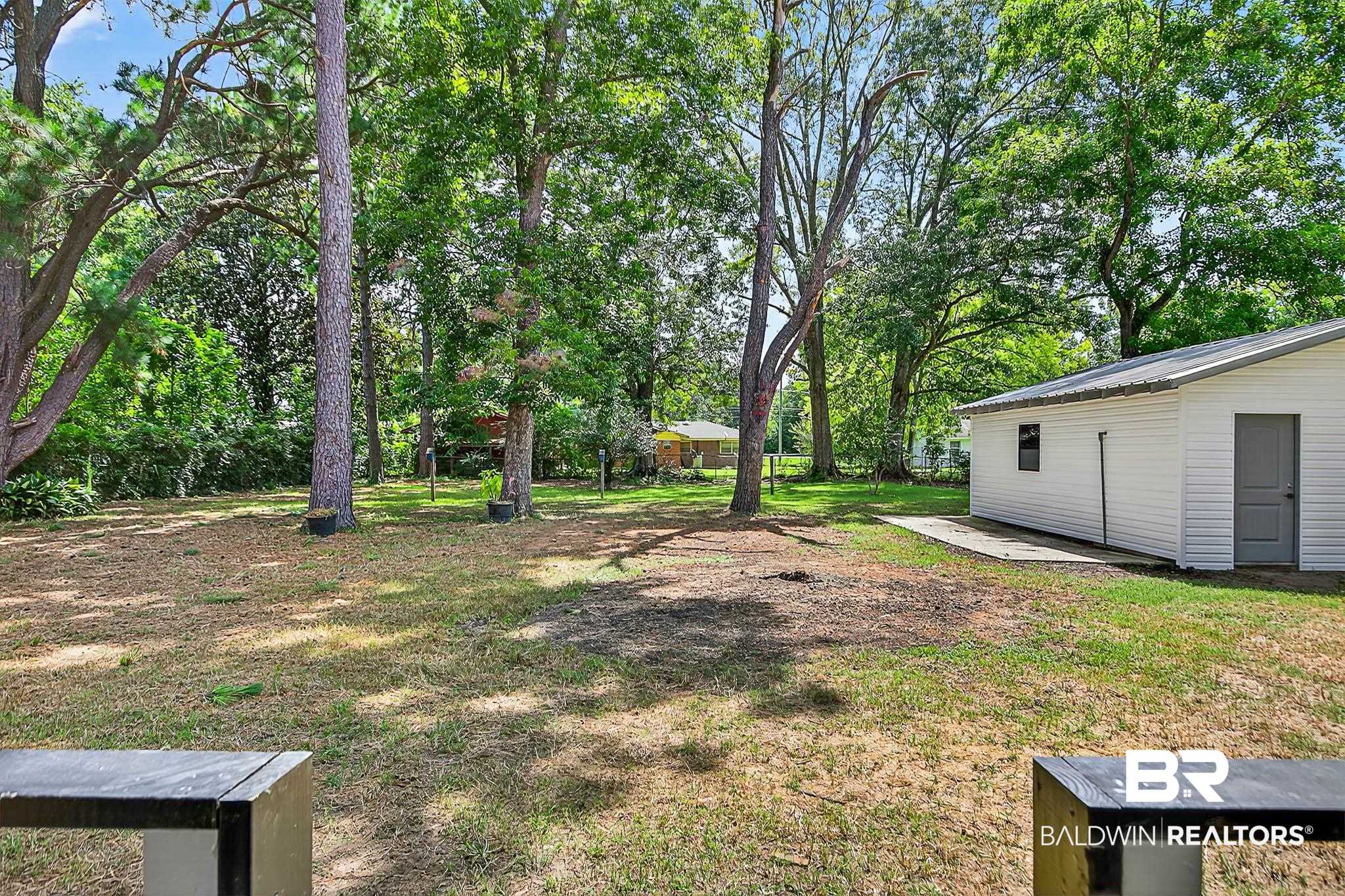 101 Terry Avenue Brewton, AL 36426 - Photo 13 of 48 View of green lawn featuring view of scattered trees and an outbuilding