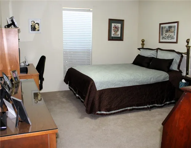 a bedroom with a bed and two windows