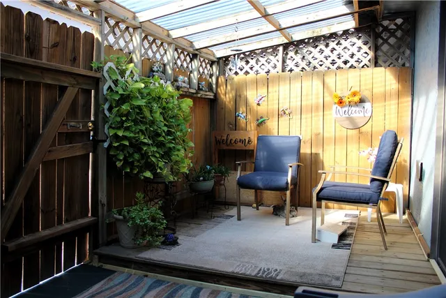 a balcony with table and chairs and potted plants