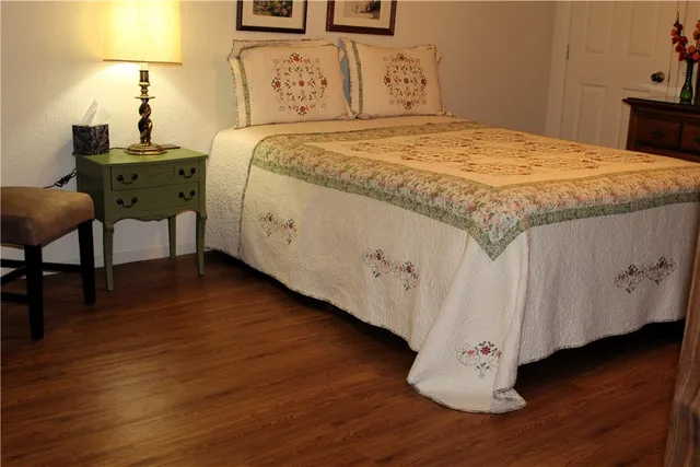 a bedroom with a bed and wooden floor