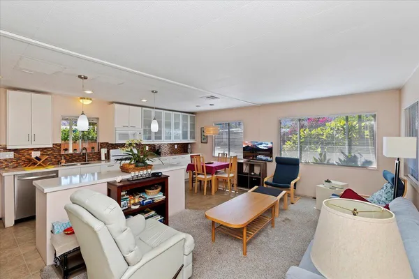 a living room with furniture and kitchen view
