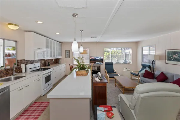 a view of a dining room with furniture a chandelier and wooden floor