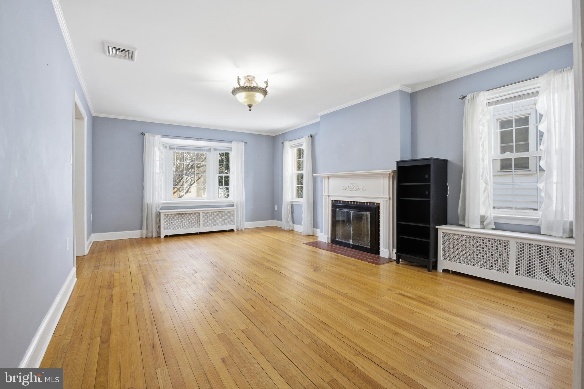 68 Maple Avenue Littlestown, PA 17340 - Photo 10 of 37 an empty room with windows fireplace and wooden floor