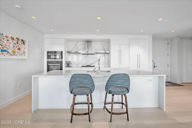 a kitchen with stainless steel appliances granite countertop a sink and a refrigerator