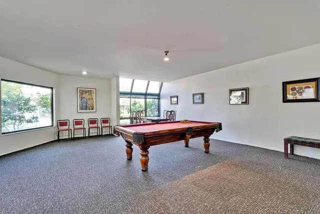 a room with furniture pool table and windows