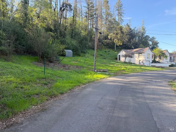 a view of a house with a yard and basketball court