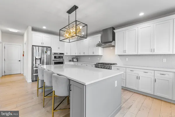 a kitchen that has a lot of cabinets in it and stainless steel appliances