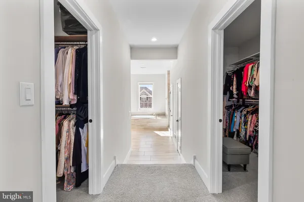 a view of a hallway with closet and a bathroom