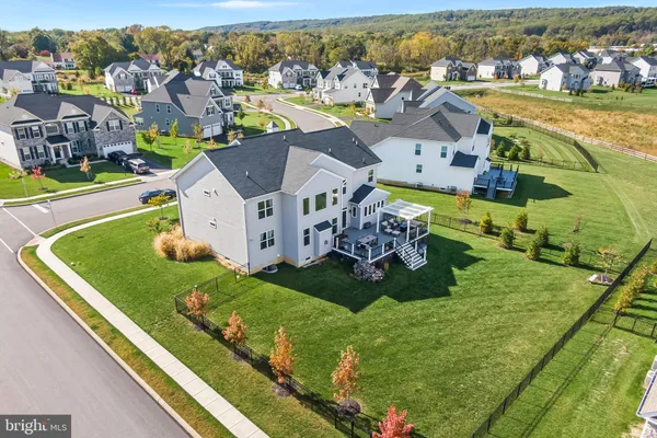 an aerial view of residential houses with outdoor space and ocean view