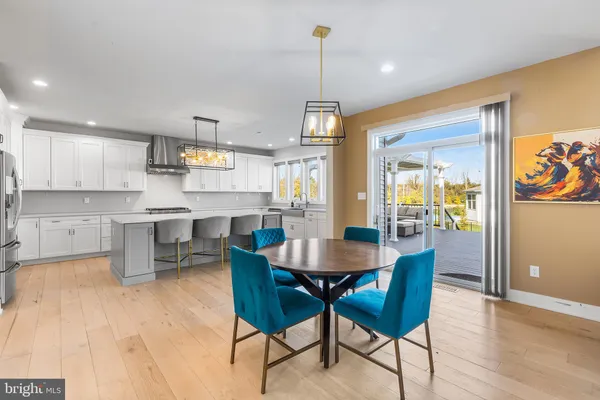 a dining room with stainless steel appliances kitchen island granite countertop a table chairs and a refrigerator