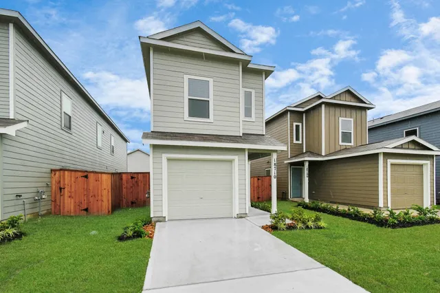 a front view of a house with a garden and yard