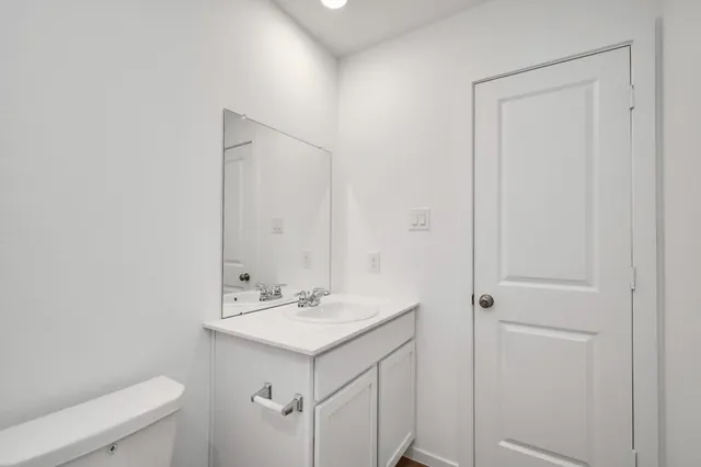 a bathroom with a sink a toilet and a mirror