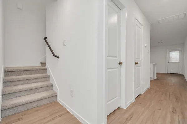 a view of a hallway with wooden floor and entryway