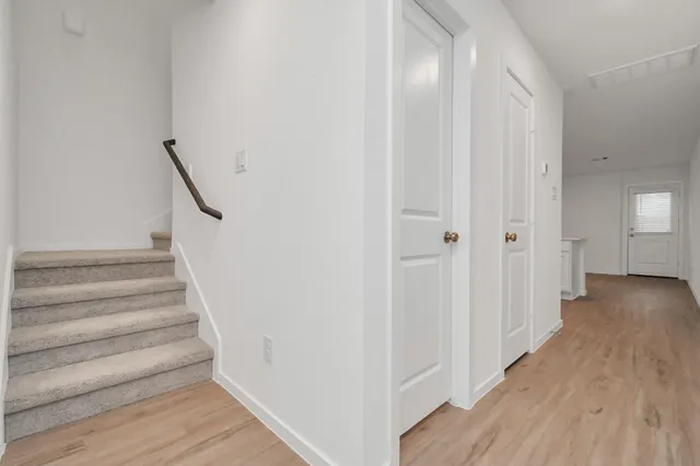 a view of a hallway with wooden floor and entryway