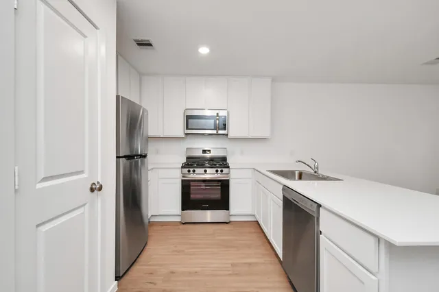 a kitchen with a refrigerator sink and stove