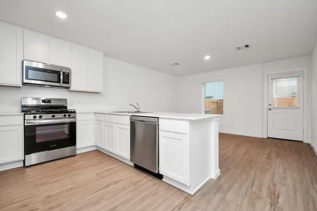 a kitchen with a sink and steel appliances