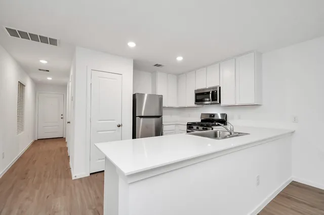 a kitchen with stainless steel appliances a refrigerator sink and microwave