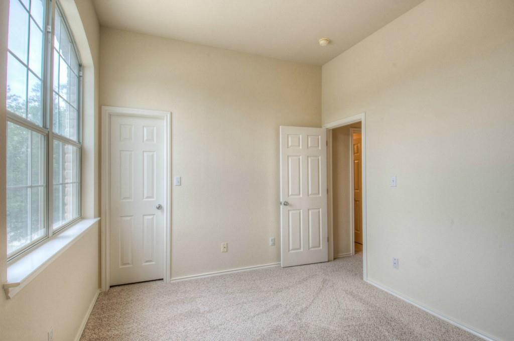 14813 Jacks Pond Road Austin, TX 78728 - Photo 11 of 29 Carpeted room featuring a large arched window with grid panes, neutral-toned walls, and white trim