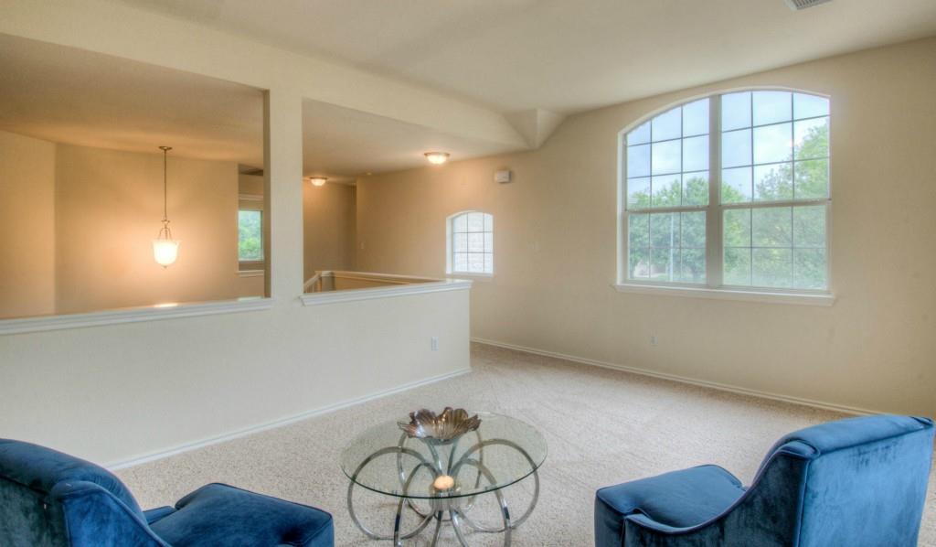 14813 Jacks Pond Road Austin, TX 78728 - Photo 13 of 29 Expansive upper-level space featuring an arched window, plush carpeting, a partial wall with an open concept, and a hanging pendant light fixture
