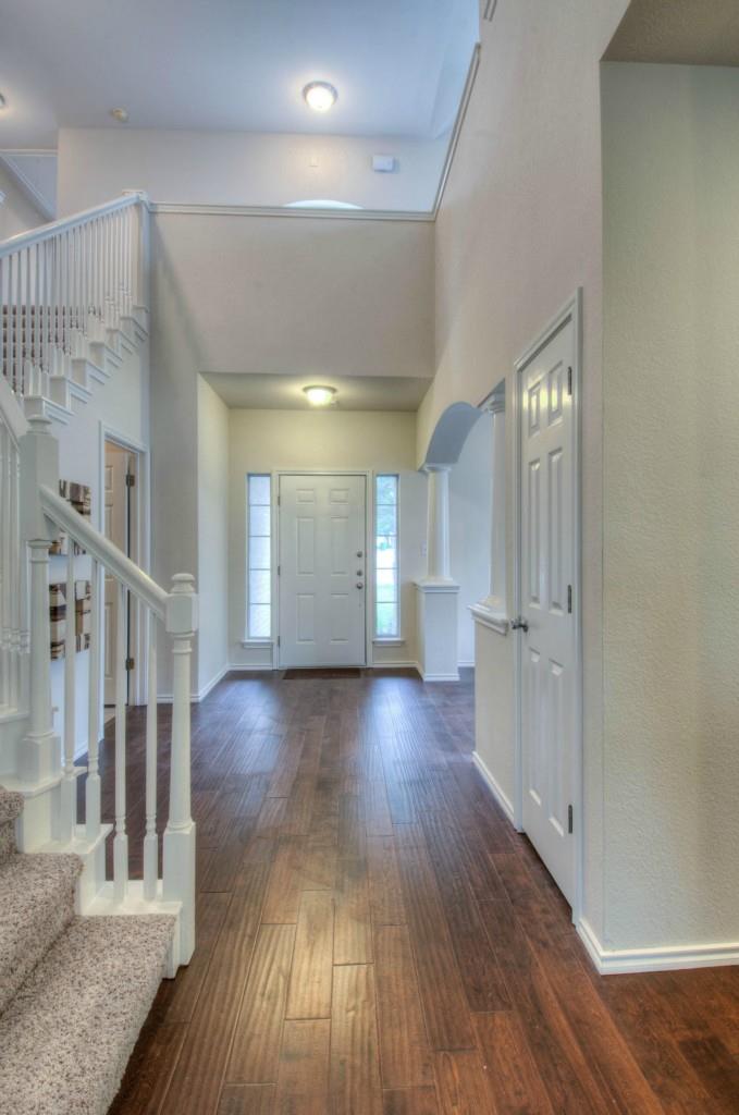 14813 Jacks Pond Road Austin, TX 78728 - Photo 15 of 29 Grand entry foyer featuring wood-finish flooring, a two-story ceiling, and a prominent staircase with white banisters