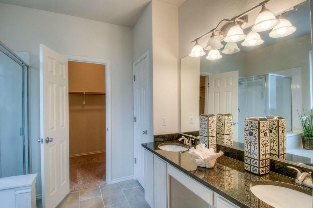 14813 Jacks Pond Road Austin, TX 78728 - Photo 18 of 29 Bathroom featuring a dual vanity with dark countertops, undermount sinks, and chrome fixtures