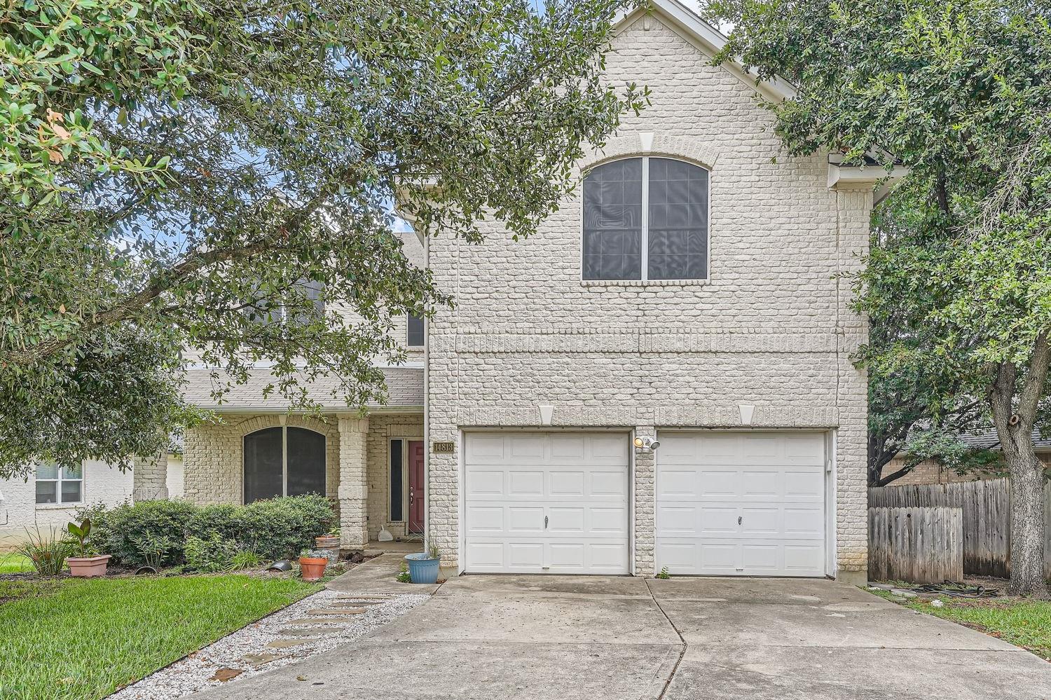 14813 Jacks Pond Road Austin, TX 78728 - Photo 2 of 29 Two-story residence featuring a light-colored brick facade, an arched entry porch, and a two-car garage