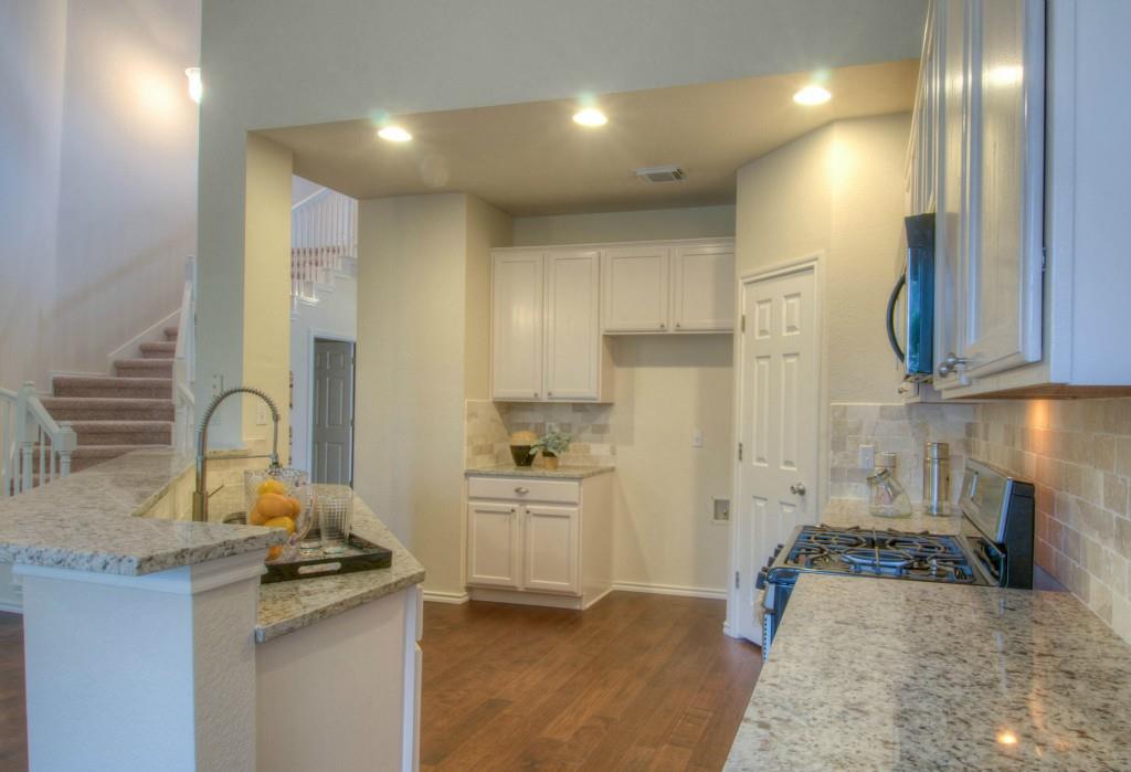 14813 Jacks Pond Road Austin, TX 78728 - Photo 22 of 29 Kitchen featuring granite countertops, a gas range, white cabinetry, tile backsplash, and wood-finish flooring