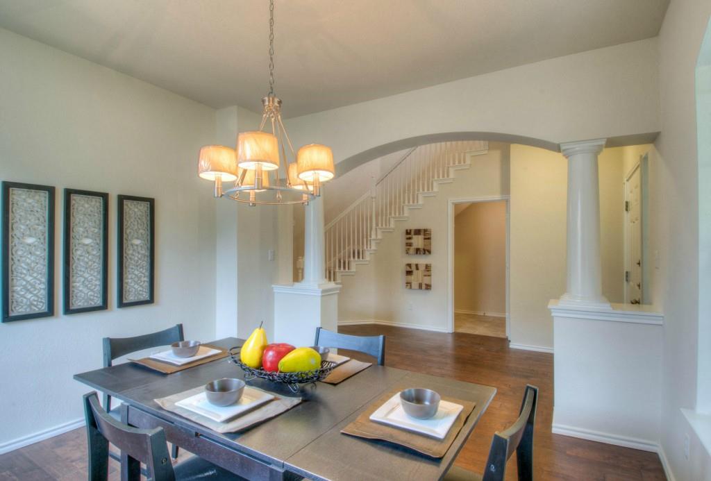 14813 Jacks Pond Road Austin, TX 78728 - Photo 27 of 29 Formal dining area featuring wood-finish flooring, a contemporary chandelier, and an arched entryway