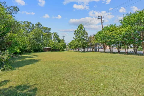 a view of green field with trees in the background