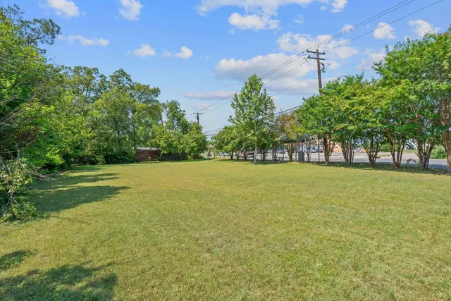 a view of green field with trees in the background