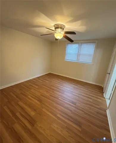 a view of a room with wooden floor and ceiling fan