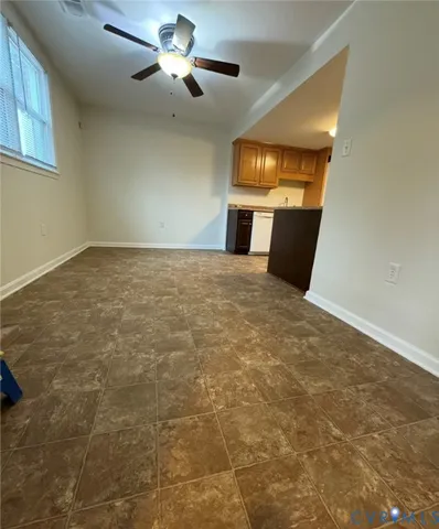 a view of an empty room with a fireplace and a window