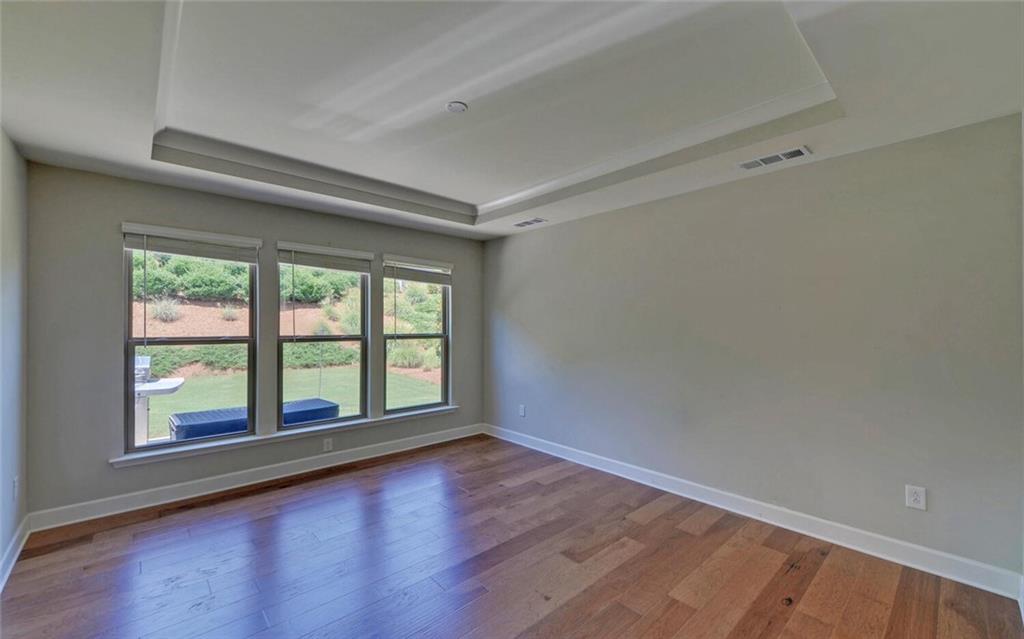 5825 Maple Bluff Way Hoschton, GA 30548 - Photo 24 of 67 wooden floor in an empty room with a window