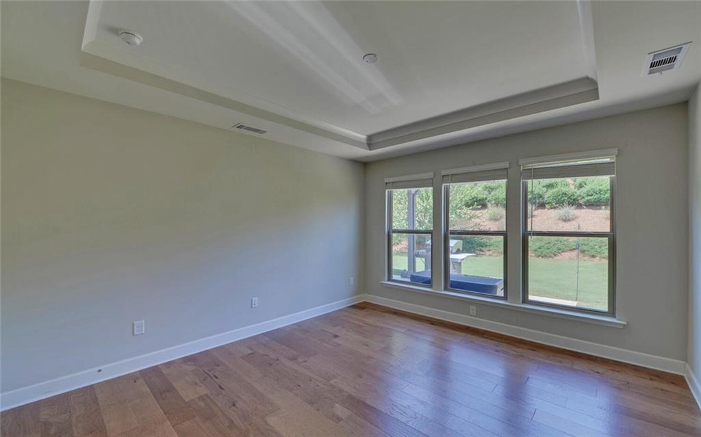 5825 Maple Bluff Way Hoschton, GA 30548 - Photo 26 of 67 wooden floor in an empty room with a window