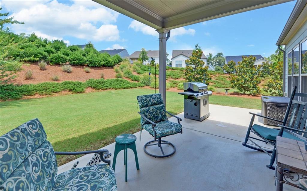 5825 Maple Bluff Way Hoschton, GA 30548 - Photo 40 of 67 a view of a chairs and table in patio with a lake view