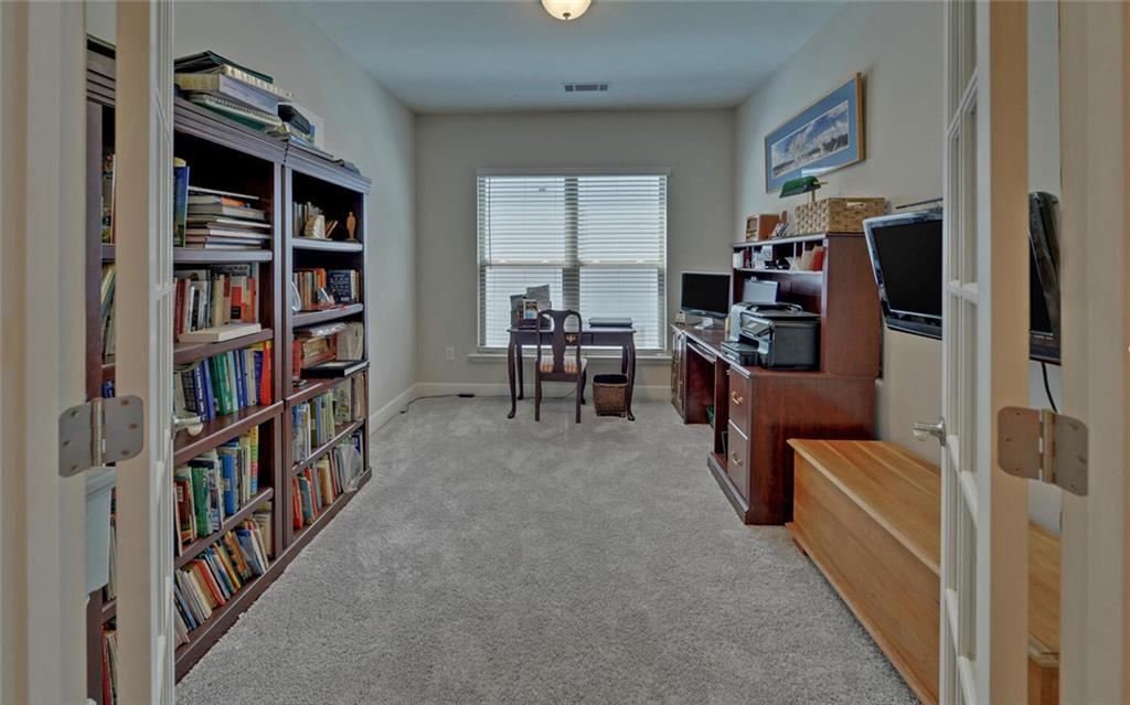 5825 Maple Bluff Way Hoschton, GA 30548 - Photo 10 of 67 a view of a workspace with furniture and a book shelf