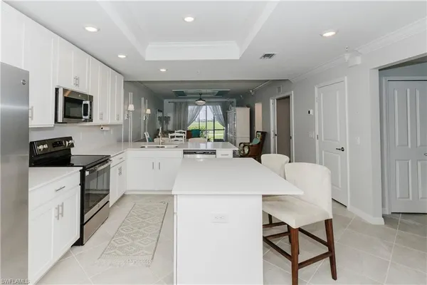 a kitchen with a sink a microwave and cabinets