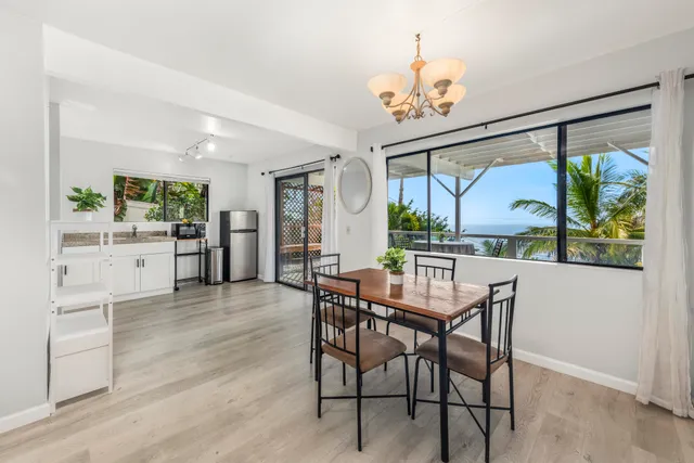 a dining room with furniture a large window and a chandelier