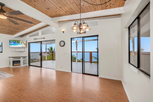 a view of a livingroom with fireplace a chandelier and wooden floor