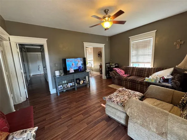 a living room with furniture and a flat screen tv with wooden floor