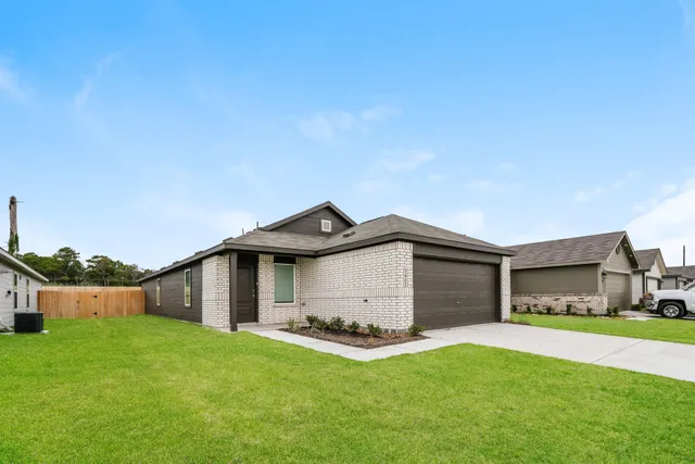 a front view of a house with a garden and yard