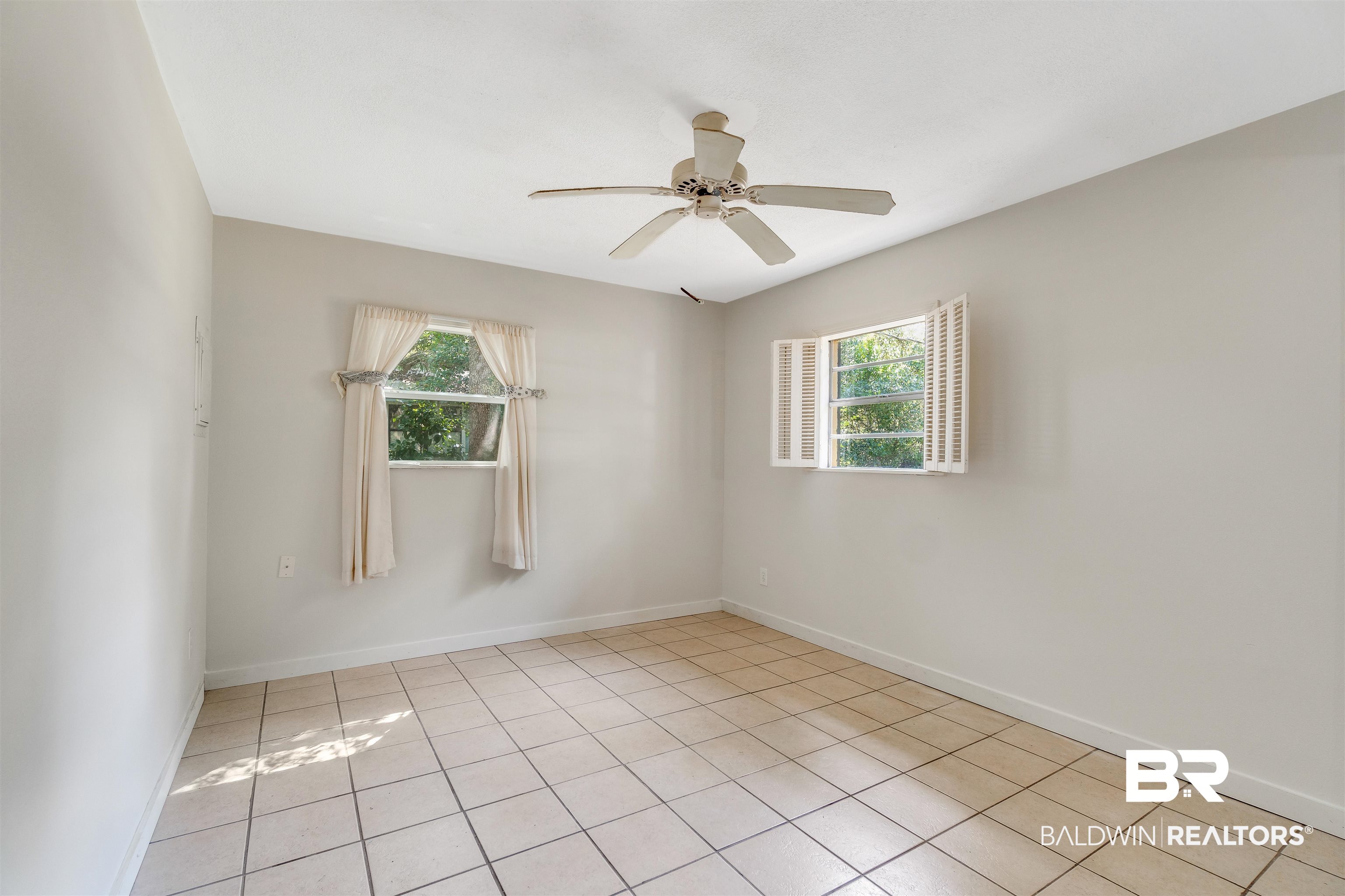 34341 Lost River Road Seminole, AL 36574 - Photo 19 of 36 Unfurnished room featuring healthy amount of natural light, light tile patterned floors, and a ceiling fan