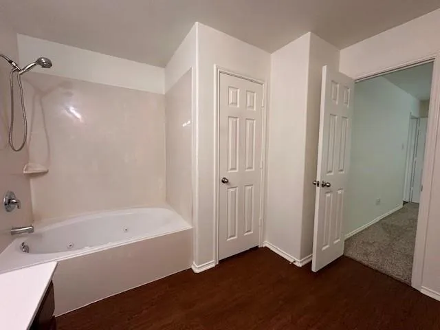 a bathroom with a tub sink and mirror
